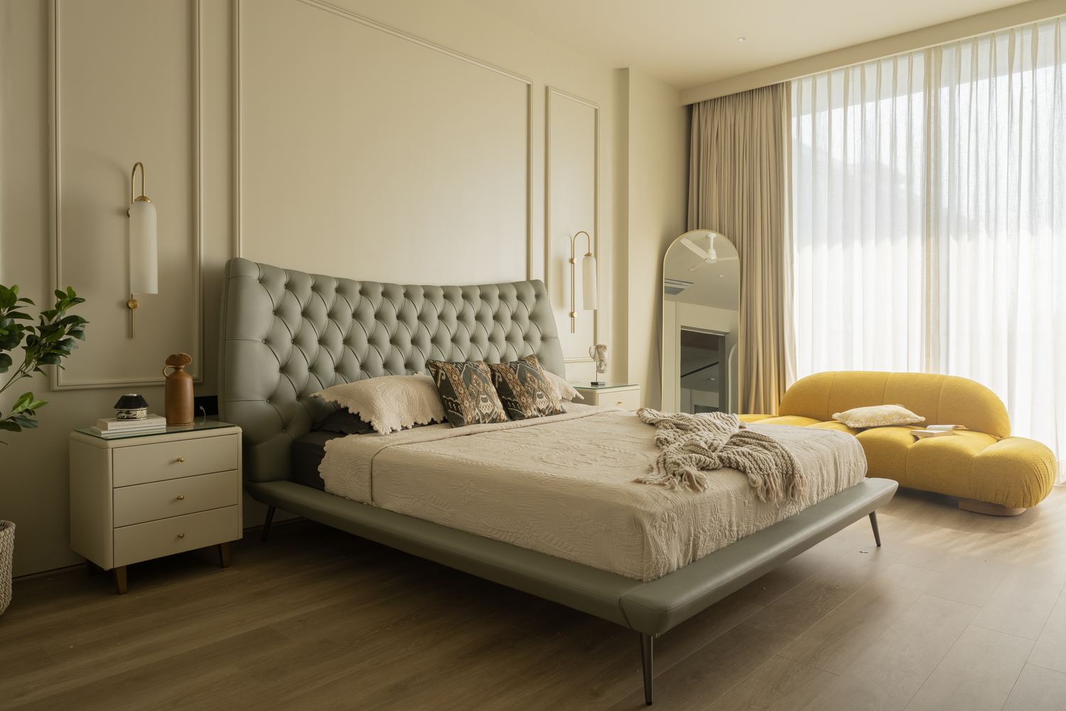 A bedroom in daylight with sheer curtains drawn across the window