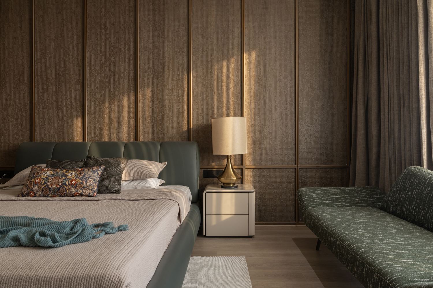 A bedroom lit by a single bedside lamp in the evening